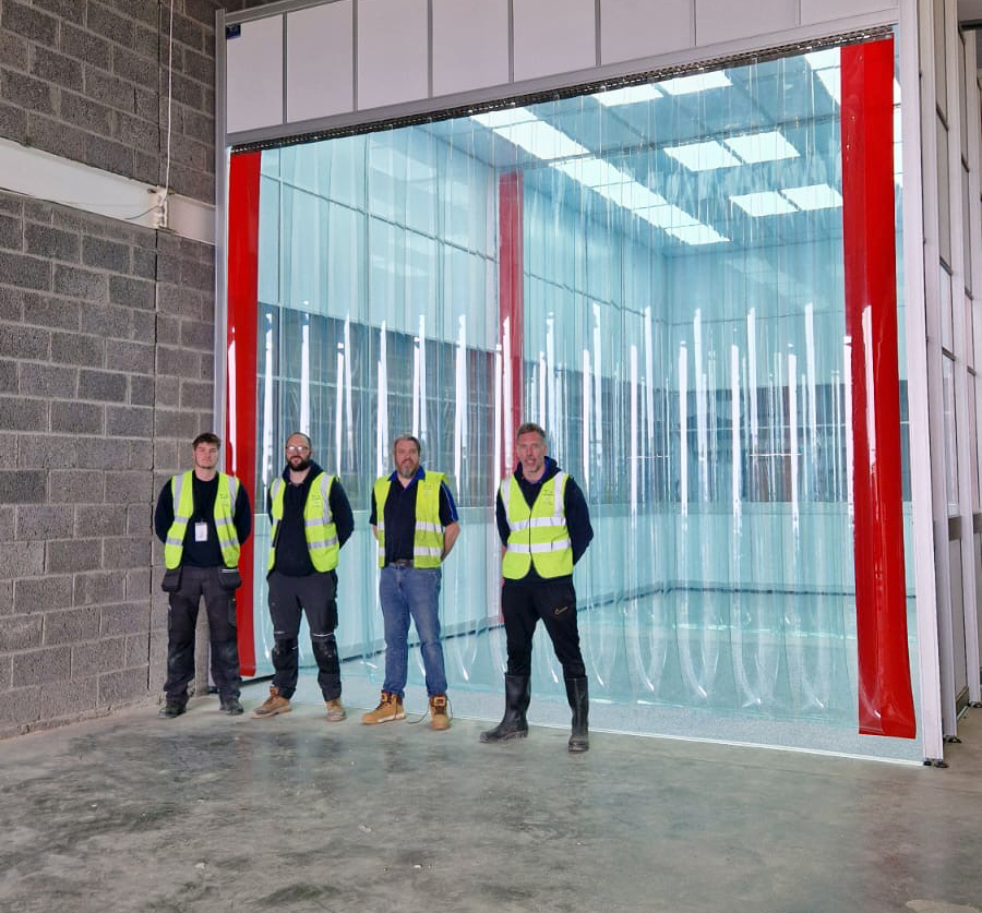 TCA team photo outside a large door